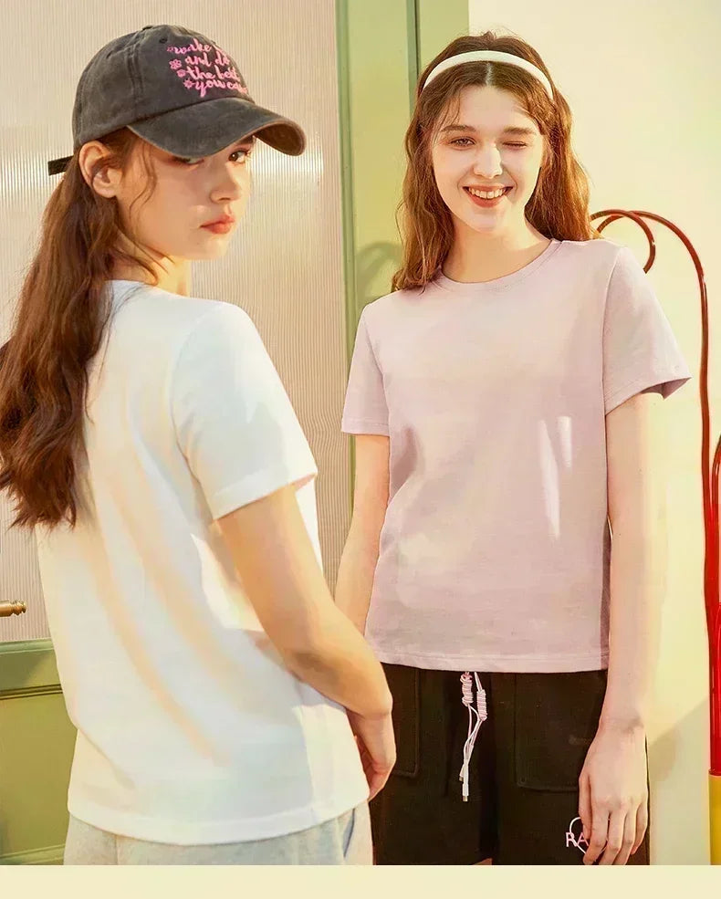 Two models showcasing trendy casual t-shirts, one in white and the other in light pink, highlighting youthful fashion style.